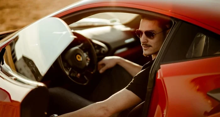 man in black shirt sitting in red car